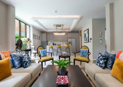 A living room in a townhouse in Bangkok is set up for a real estate photo shoot with colorful pillows.
