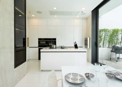 Modern bright colored kitchen with sleek design. Professional Real Estate Photography service in Thailand.