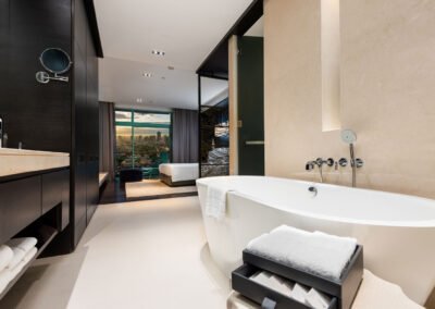 Modern hotel bathroom with city view. Luxurious hotel photography created by professionals in Bangkok, Thailand.